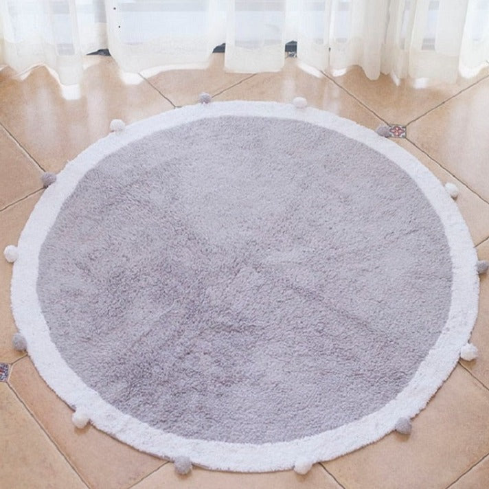 Puszysty okrągły dywan z pomponami